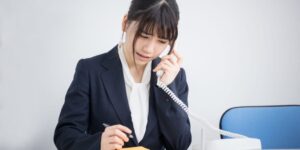 電話取次ぎ対応をする女性
